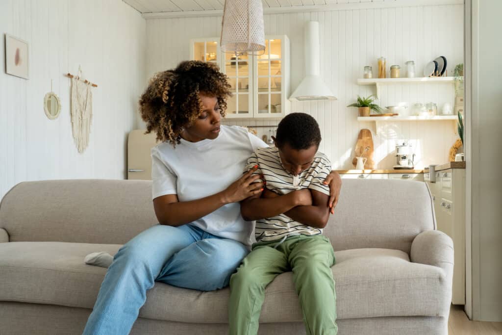 Loving african american mother embracing sad offended little son, giving support to child